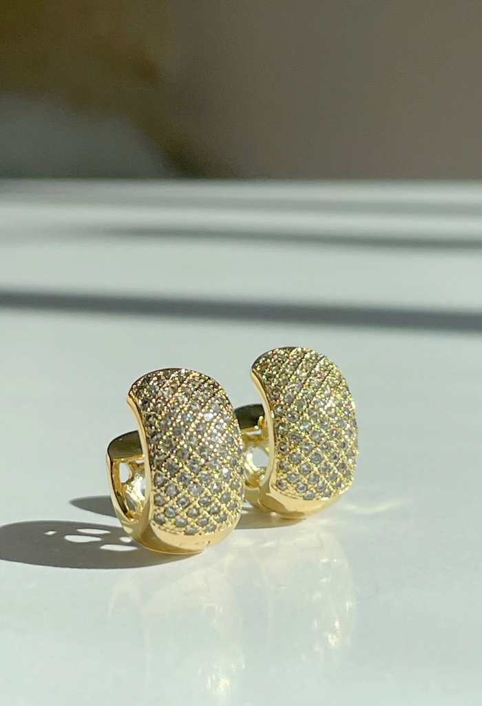 Soleil Diamond Pavé
Easy glow, elevated. Our Soleil Pavé Huggies wrap a thicker hoop in lines of pavé cz stones for clean, chic shine. Lightweight with a comfy snap-close hinge, they’re the pair you’ll wear on repeat—from coffee run to cocktails.