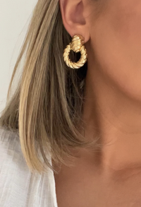 Introducing our "Knock Out" Earrings—a modern twist on the classic doorknocker. Crafted in 18k gold-filled with a chic croissant texture, these earrings make a statement that’s bold yet wearable. Designed with a secure stud backing for all-day comfort, they're the effortlessly stylish piece you'll never want to take off.