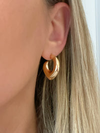 Chunky gold hoops with pointed ends, a versatile statement piece for any occasion