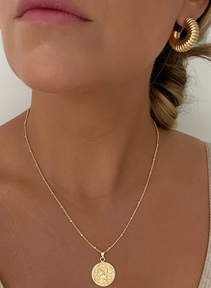 18k Gold-Filled Zodiac Coin Necklace – Celestial elegance for modern women. Versatile and empowering, a symbol of unique traits and timeless style. Product Modeled. 