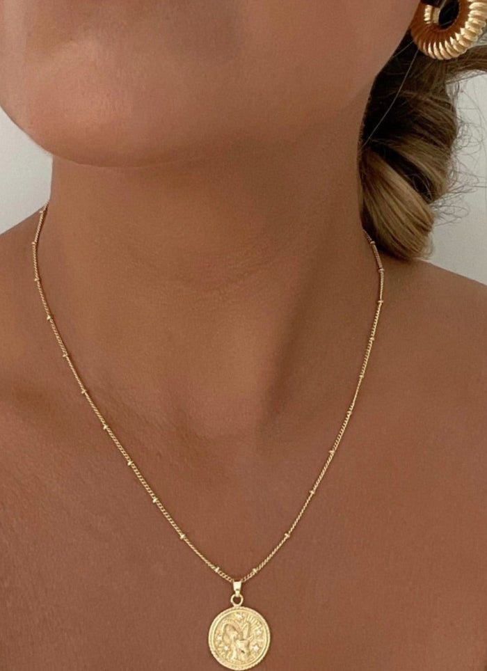 18k Gold Filled Zodiac Coin Necklace by Dylan Rae Jewelry, showcasing intricate zodiac symbols, customizable lengths, and various chain styles, embodying celestial elegance and personalized style.
