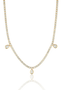 This striking 18k gold-filled tennis necklace is designed to turn heads with its timeless elegance. Crafted with luminous cubic zirconia stones and featuring three delicate teardrop CZ accents, it adds just the right touch of sophistication.&nbsp;