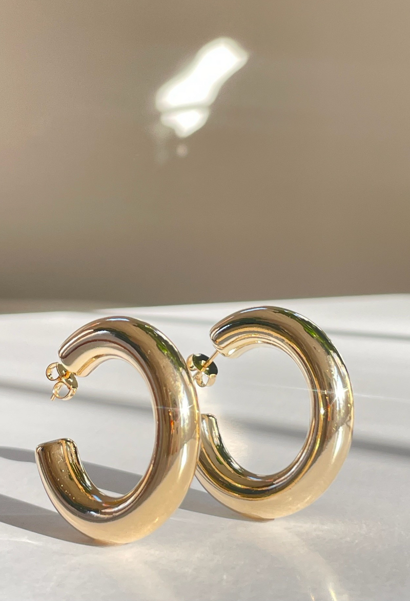 Elevate your look with the Rock With You Thick Gold Tube Hoops from Dylan Rae. These substantial hoops offer a modern twist on a classic design, ideal for trendy fashionistas